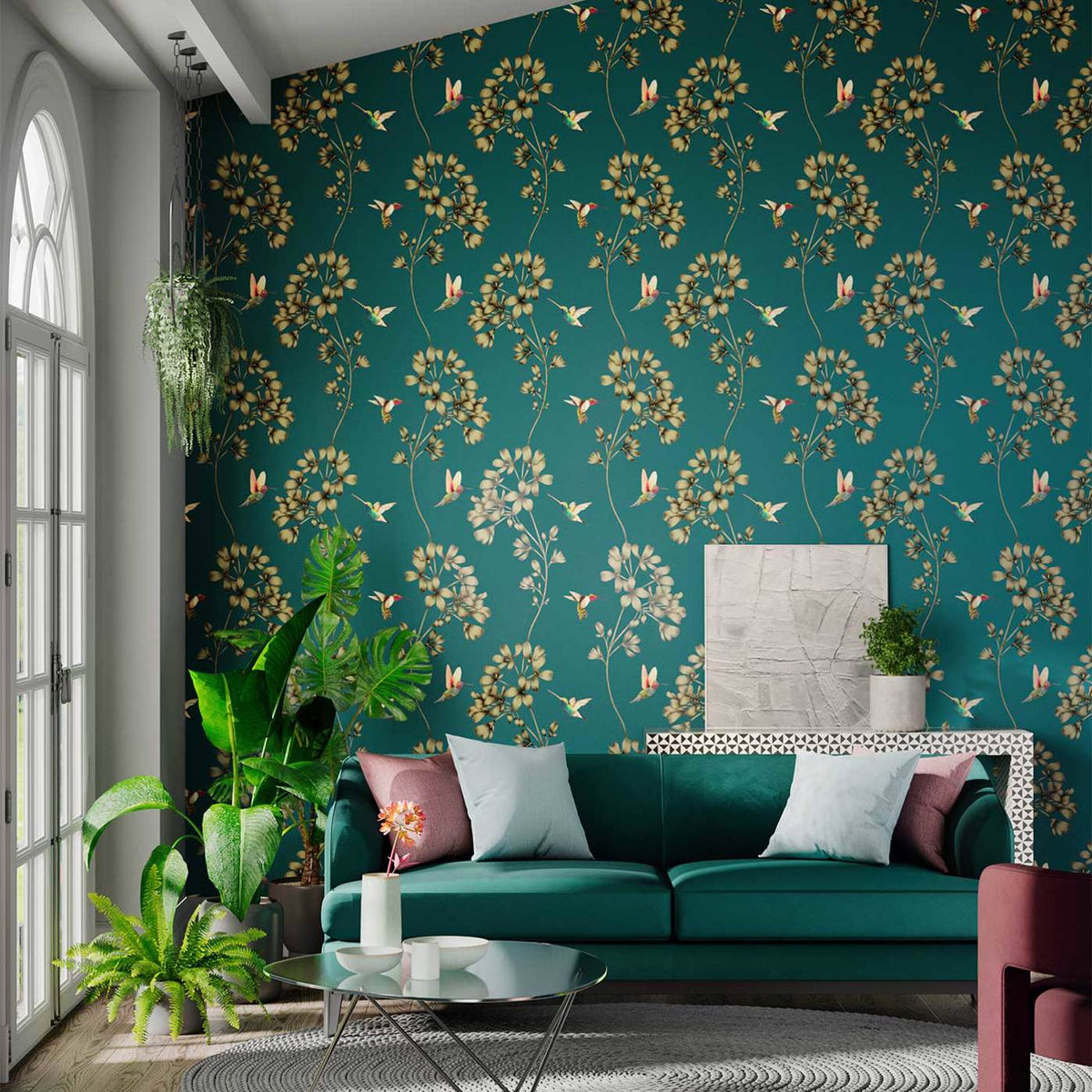 Living room with teal floral wallpaper and golden-hued flowers, green sofa, potted plants, and large arched windows letting in daylight